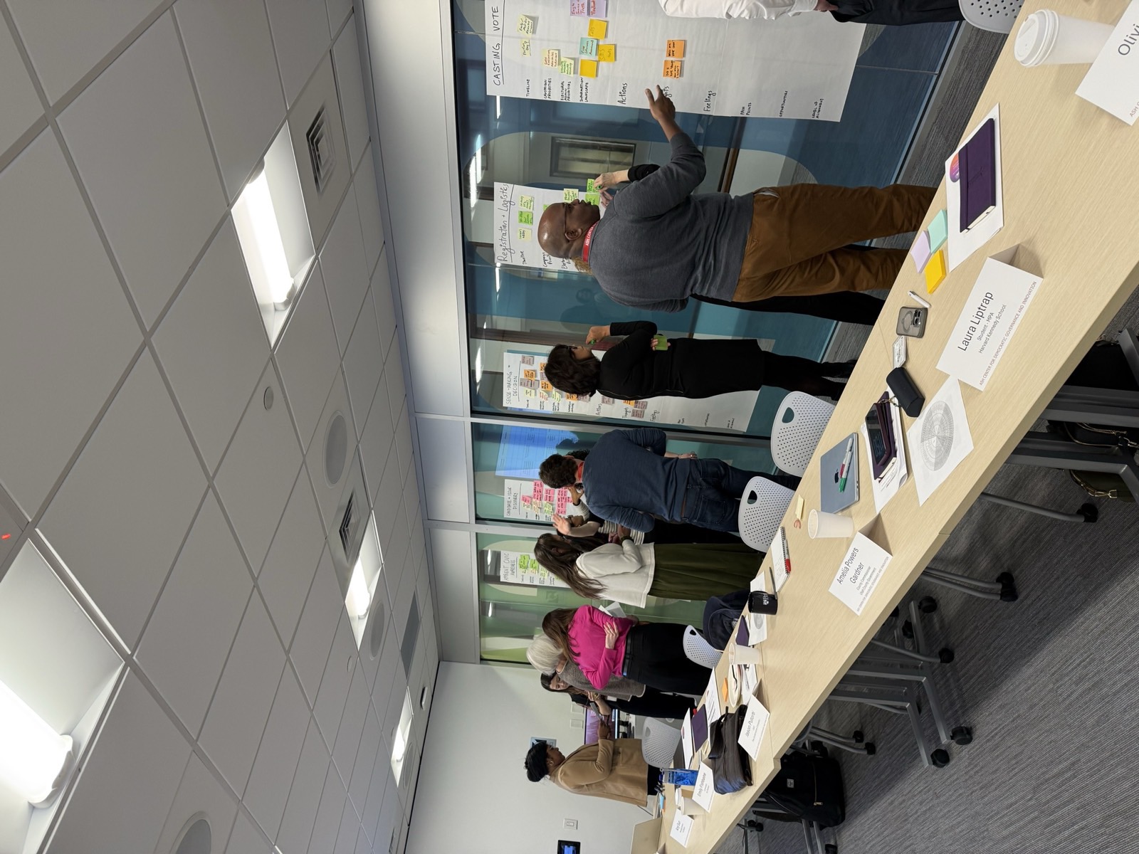 Participants documenting the registration and logistics and casting vote stages with colored sticky notes.